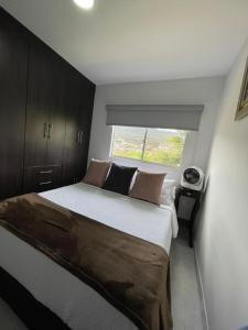 um quarto com uma cama grande e uma janela em Apartaestudio San Gil - Hostal Green em San Gil