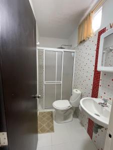 uma casa de banho com um chuveiro, um WC e um lavatório. em Apartaestudio San Gil - Hostal Green em San Gil