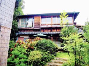 una casa con una escalera que conduce a ella en atami onsen guesthouse nagomi en Atami