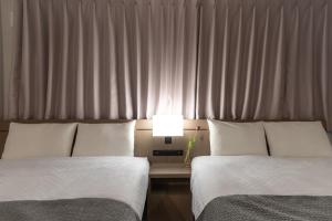 two beds in a hotel room with a window at BON Kyoto Kiyomizu in Kyoto