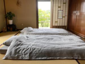 2 aparte bedden in een kamer met een raam bij hanare in Yamanashi