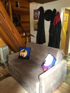 um sofá com duas almofadas numa sala de estar em Chalé da Magia em Campos do Jordão