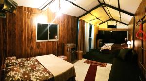 um quarto com duas camas e uma tv nele em Kithul Cottage em Nuwara Eliya
