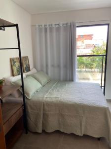 a bedroom with a bed and a window at Maraca Beach in Porto De Galinhas