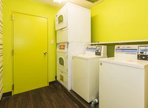 a room with a yellow door and some machines at FLEXSTAY INN Kawasaki Ogawacho in Kawasaki