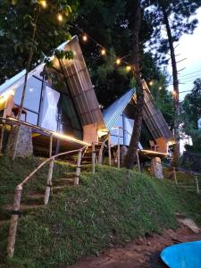 een huis op een heuvel met lichten erop bij D'Paseban Glamping in Bogor