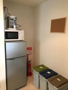 a kitchen with a microwave on top of a refrigerator at 札幌市にある１０人宿泊可能物件 in Atsubetsu