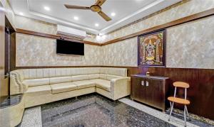 a living room with a couch and a flat screen tv at Treebo Trend Sripadha Residency Alipiri Road in Tirupati