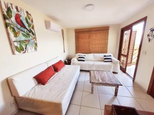 Residência em condom, 1 ou 2 suítes, vista para o mar, Praia do Curral, Ilhabela في إلهابيلا: غرفة معيشة مع أريكة وطاولة قهوة +75 صورة