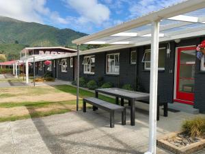 a picnic bench in front of a building with awning at AAA Marlin Motel in Picton