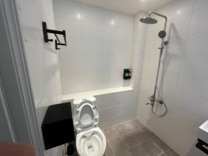 a bathroom with a toilet and a shower at Rolling Pin Homestay in Tainan