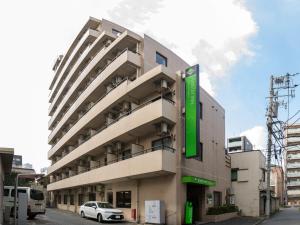 un edificio con un'auto parcheggiata di fronte di FLEXSTAY INN Tamagawa a Kawasaki