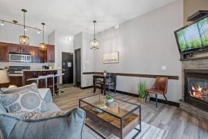 Una sala de estar con un sofá y una chimenea. en Nature's Nook by Instant Suites Pool & HotTub, en Canmore