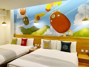 two beds in a room with a painting at Sun Dialogue Hotel-By Cosmos Creation in Chiayi City