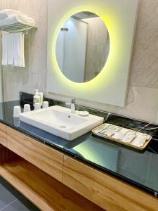 uma casa de banho com um lavatório e um espelho em Sun Dialogue Hotel-By Cosmos Creation em Chiayi City