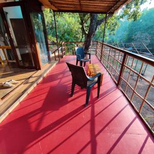 a red deck with a bench and a chair on it at Samyama Retreat in Cola