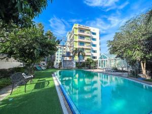 a swimming pool in front of a building at โรงแรม ชาโตว์วิสต้า in Chon Buri