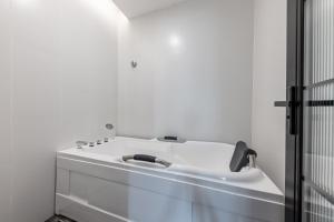 a white bathroom with a sink and a shower at 银座精宿酒店（济南泺源大街泉城广场宽厚里店） in Jinan