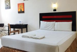 a bedroom with a bed with two towels on it at RedDoorz @ Mountain Citi Tourist Inn Canlaon in Panubigan
