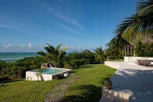 a backyard with a swimming pool and the ocean at Qambani Luxury Resort in Michamvi