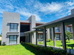 a modern house with a green lawn at Kambaniru Beach Hotel and Resort in Waingapu