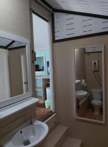 a bathroom with a sink and a toilet and a mirror at Phangan Beach Resort in Baan Tai