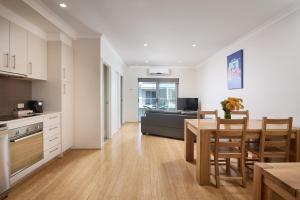a kitchen and dining room with a table and chairs at Airport Apartments by Vetroblu in Perth