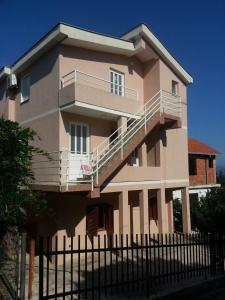 a building with a balcony and a fence at Apartments Nada in Utjeha