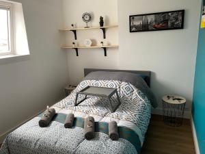 a bedroom with a bed with a table on it at le nid douillet de la gare centre ville de Lens in Lens