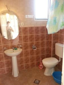 um homem a tirar uma foto de uma casa de banho com WC e lavatório em Apartments Nada em Utjeha