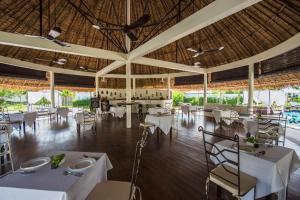 a restaurant with white tables and chairs and a large ceiling at Navutu Dreams Resort & Wellness Retreat in Siem Reap