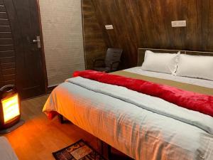 Un dormitorio con una cama con una manta roja. en Cottages Amid Mountains en Joshīmath