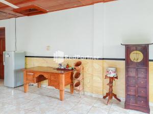 W kuchni znajduje się drewniane biurko i lodówka. w obiekcie Nando House w mieście Ubud