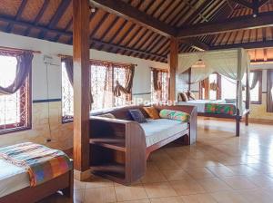 a bedroom with two beds in a room with windows at Nando House in Ubud