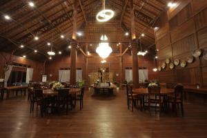 a large room with wooden tables and chairs and lights at Kasuari Exotic Resort Magelang in Magelang