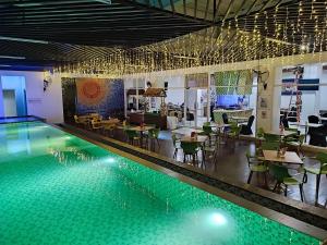 een zwembad met tafels en stoelen en een restaurant bij KHAS Makassar Hotel in Makassar