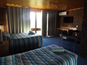 a hotel room with a bed and a desk at Rivergum Motel in Echuca