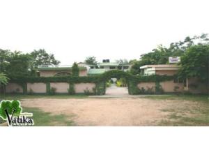 a house with an archway in front of a yard at Vatika Resort in Sawāi Mādhopur