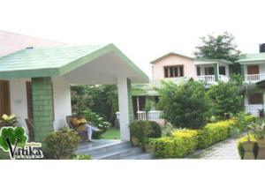 a person sitting on a porch of a house at Vatika Resort in Sawāi Mādhopur