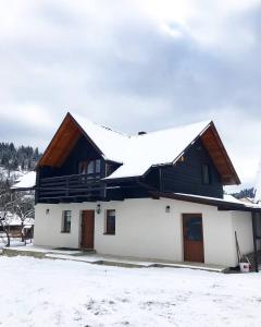 uma casa com neve em cima em Happy House em Slavske