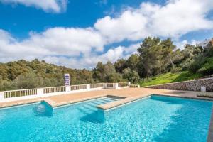 une piscine à l'eau bleue face à une montagne dans l'établissement Appartamento Marianda - Son Bou, à Son Bou