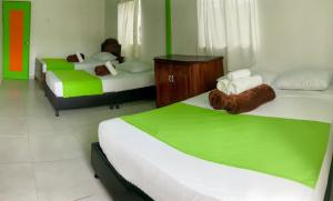 a bedroom with two beds with green and white at Room in Guest room - Room with 1 double bed and 2 single beds Number 8 in Rizaralda