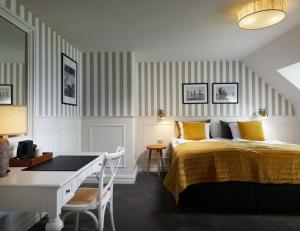a bedroom with a bed and a table and a desk at Gl. Avernæs Sinatur Hotel & Konference in Ebberup