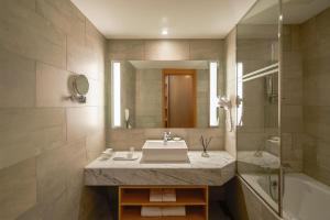 a bathroom with a sink and a tub and a mirror at Mayfield Hotel Seoul in Seoul