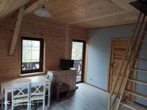 a living room with a staircase in a log cabin at Apartament "Cichy kącik" in Lubawka