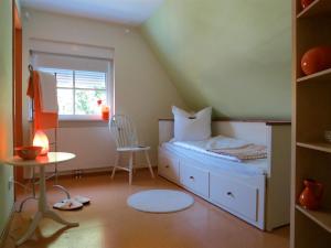オーバーアスバッハにあるÖkoHausNamastéの小さなベッドルーム(ベッド1台、椅子付)