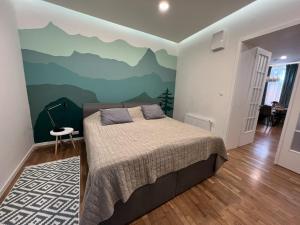 a bedroom with a bed with a mountain mural on the wall at FLEXIHOME sk - Design City - top Location close city centre - big squared in Košice