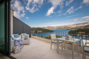 a balcony with a table and chairs and a view of the water at Green Hill Penthouse apartment in Korčula