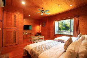 a bedroom with two beds and a television in a room at Hejia Hot Spring Hotel in Ren'ai