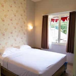 バトゥにあるRosetta Homestayのベッドルーム(白いベッド1台、窓付)
